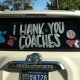 Photo of the back of an SUV with the words Thank you Coaches.