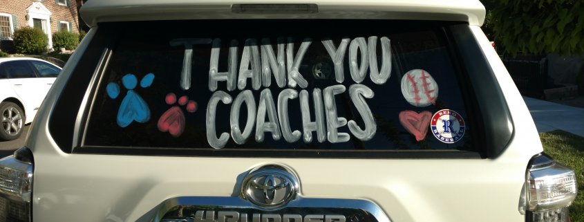 Photo of the back of an SUV with the words Thank you Coaches.